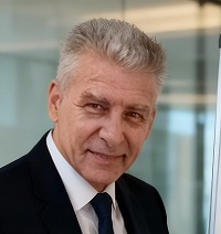 Orlando Fussoni, especialista en estrategia digital y posicionamiento SEO, retrato profesional con traje oscuro, camisa blanca y corbata azul en oficina moderna