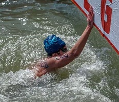 Tomás Jouglard nadando en aguas abiertas, llegando a la zona de meta apoyando su mano en la boya de llegada durante competencia deportiva